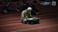 Jemaah membaca kitab suci Alquran usai salat di Masjid Istiqlal, Jakarta, Selasa (7/5/2019). Umat muslim meningkatkan ibadah pada bulan suci Ramadan dengan membaca Alquran (tadarus), salat berjemaah, berdoa, dan zikir di masjid. (Liputan6.com/Faizal Fanani)