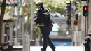 Seorang polisi berlari mengepung situasi kafe Lindt di Sydney, Australia (15/12/2014). Puluhan sandera terperangkap di dalam kafe Lindt di Sydney, Australia. (REUTERS/Jason Reed)
