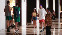 Pebasket Kanada, Dillon Brooks (tengah kanan) berjalan bersama sang kekasih, Danielle atau yang dikenal Big Bambina sambil membawa bungkusan di lobi hotel mereka menginap pada Kamis (24/08/2023). (Bola.com/Bagaskara Lazuardi)