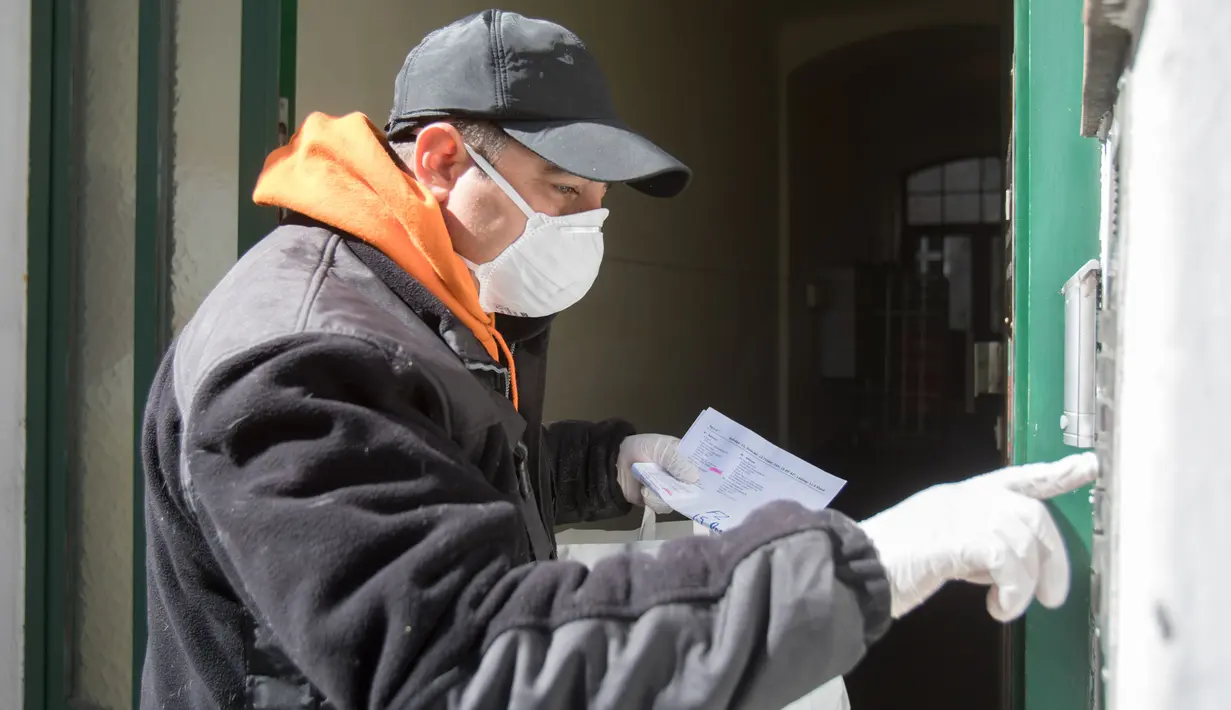 Pengemudi kereta kuda mendatangi sebuah rumah di distrik ke-3 di Wina, Austria pada 8 April 2020. Kereta yang disebut Fiaker yang biasanya mengangkut turis berkeliling, kini semenjak pandemi Corona beralih fungsi menjadi pengantar makanan untuk warga lanjut usia di daerah tersebut. (ALEX HALADA/AFP)