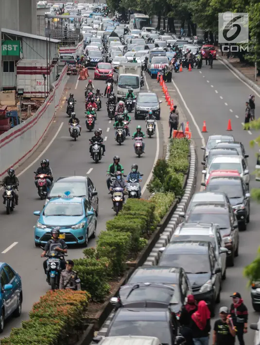 Kendaraan melintas dekat mobil pengemudi online yang menutup jalur lambat saat demonstrasi di kantor pusat Grab kawasan Kuningan, Jakarta, Senin (29/10). Aksi tersebut menyebabkan kemacaten dari arah Mampang menuju Menteng. (Liputan6.com/Faizal Fanani)