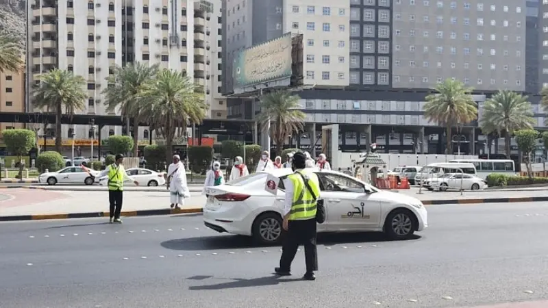 Perjuangan petugas haji dari Indonesia membantu para jemaah menyeberangi jalan di tengah cuaca panas terik Kota Makkah, Arab Saudi. (Foto: Kemenag)