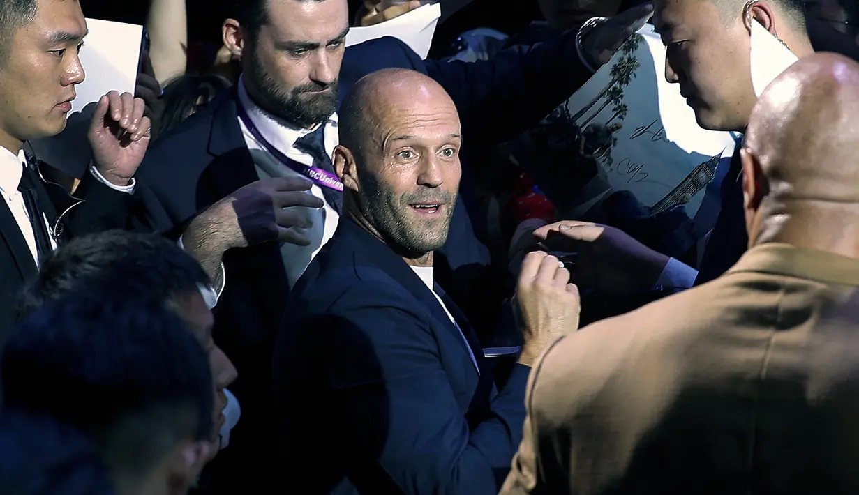 Aktor Jason Statham melihat ke arah Dwayne Johnson ketika mereka memberi tanda tangan kepada penggemar selama acara red carpet dalam premiere film 'Fast & Furious: Hobbs & Shaw' di Beijing, China, Senin (5/8/2019). (AP Photo/Andy Wong)