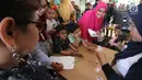 Petugas membagikan Kartu Identitas Anak (KIA)  yang sudah selesai dibuat di mal Living Wolrd Alam Sutera, Tangsel, Senin (17/12). Pembuatan KIA di mall itu untuk memudahkan masyarakat yang ingin mendaftarkan identitas anaknya. (Merdeka.com/Arie Basuki)