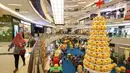 Pengunjung melintas di samping pohon Natal yang didominasi warna kuning setinggi 12 meter di Lippo Mall Kemang,  Jakarta Sabtu (14/12/2019). Pohon dengan konsep Joypixels Emoji momentum liburan menyambut Natal bersama keluarga. (Liputan6.com/Fery Pradolo)
