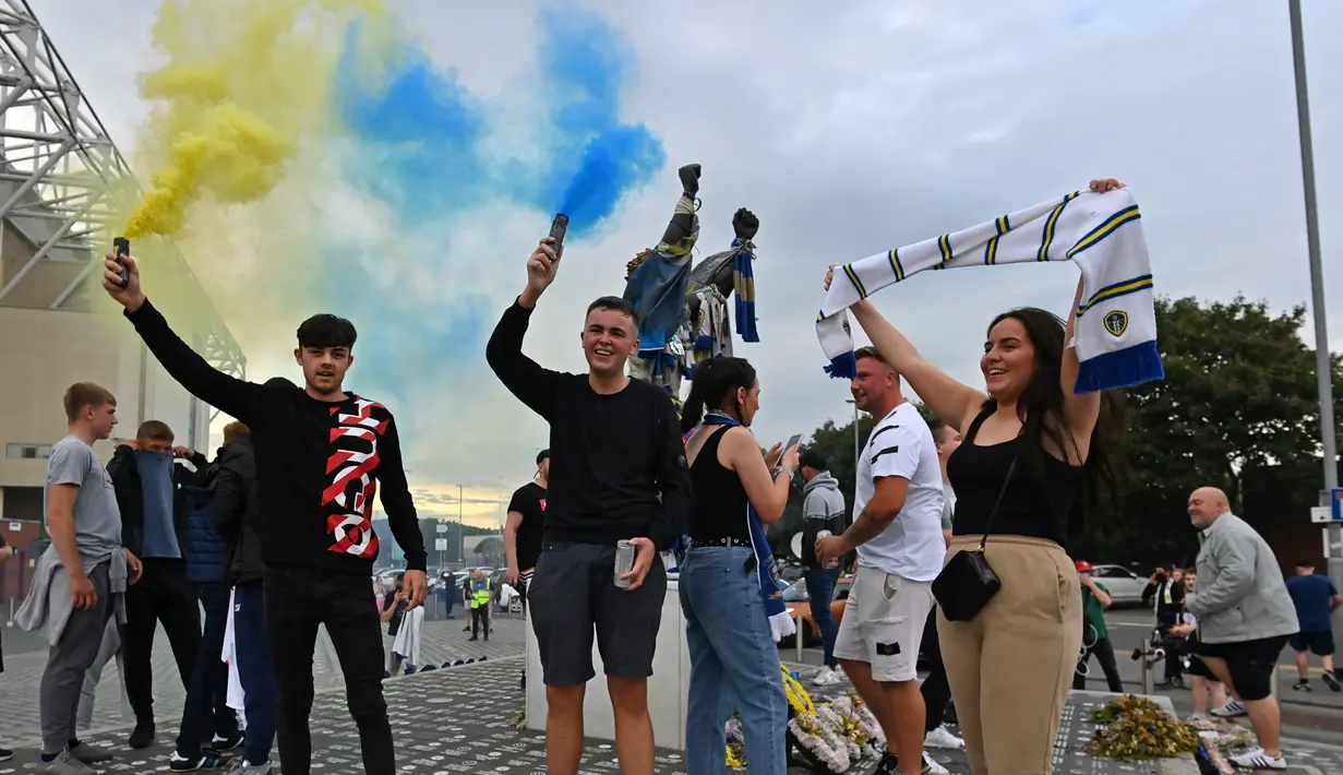 Pendukung Leeds United berkumpul di luar Elland Road merayakan kembalinya klub ke Liga Premier  di Leeds, Inggris (17/7/2020). Leeds berhasil menyegel satu tiket promosi setelah salah satu rivalnya di divisi Championship, West Bromwich Albion kalah 1-2 di kandang Huddersfield Town. (AFP/Paul Ellis)