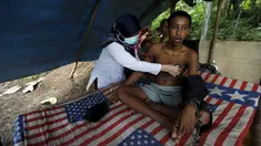 Dokter memeriksa kesehatan Deden, remaja yang dirantai di pohon oleh keluarganya di desa Longkewang, Serang, Banten, Indonesia (23/3). Tahun ini Indonesia mengirimkan tim medis untuk membantu pasien yang mengalami ganguan mental. (REUTERS/Beawiharta)