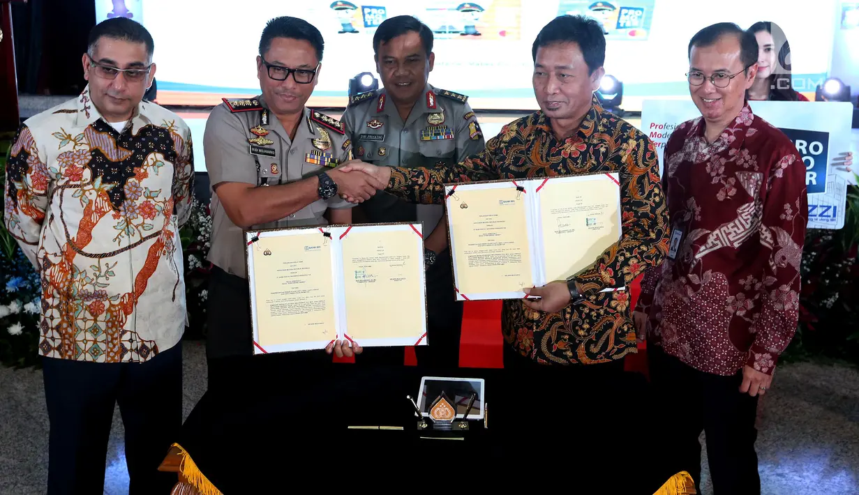 Direktur kelembagaan PT BRI, Sis Apik Wijayanto (kedua kanan) berjabat tangan dengan Kepala Pelayanan Markas Besar Polri Kombes Budi Wijanarko saat acara peluncuran Kartu BRI Promoter, Jakarta, Jumat (16/5). (Liputan6.com/Johan Tallo)