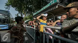 Antrian warga menunggu kedatangan bus tngkat City Tour Wisata Keliling Jakarta di halte Istiqlal, Jakarta, Kamis (7/7). Sejumlah warga memanfaatkan fasilitas bus wisata gratis untuk berkeliling Jakarta bersama keluarga. (Liputan6.com/Yoppy Renato)