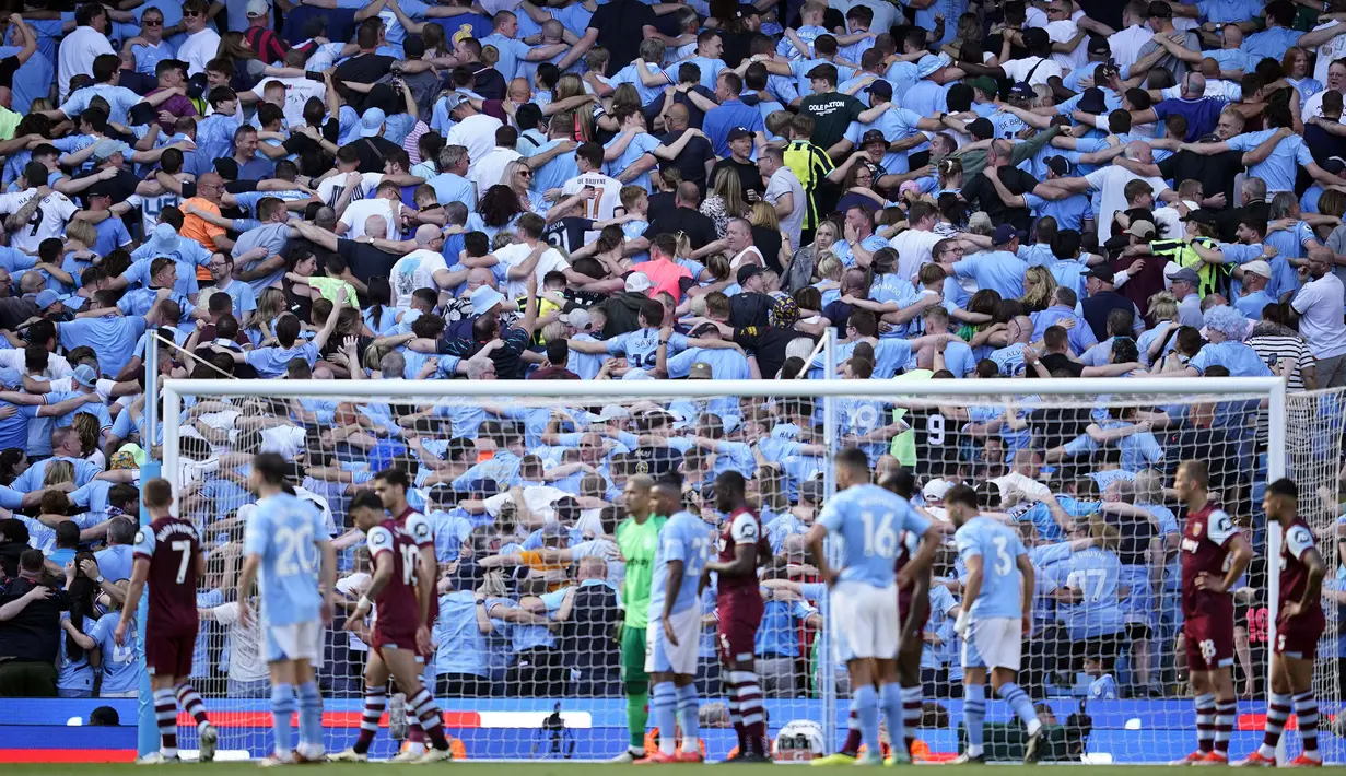 Para pendukung Manchester City di dalam stadion merayakan gol ketiga ke gawang West Ham United yang dicetak Rodrigo pada laga pekan terakhir Liga Inggris 2023/2024 di Etihad Stadium, Manchester, Minggu (19/5/2024). (AP Photo/Dave Thompson)