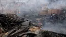 Sisa puing-puing bangunan akibat kebakaran besar yang melanda permukiman Cantagallo di Lima, Peru, Jumat (4/11). Dilaporkan, permukiman yang terbakar itu dihuni oleh komunitas Suku Amazon yang tinggal di Lima. (REUTERS/Guadalupe Pardo)