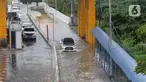 Sejumlah kendaraan melintasi Gerbang Tol Karang Tengah Barat 2 yang masih terendam banjir, Tangerang, Banten, Kamis (2/1/2020). Banjir setinggi betis orang dewasa masih menggenangi Gerbang Tol Karang Tengah Barat 2. (Liputan6.com/Angga Yuniar)