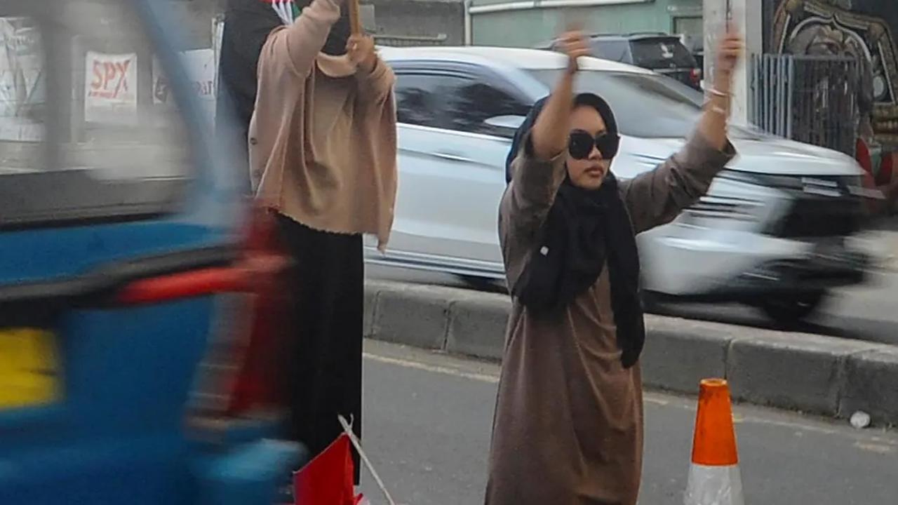 Saat menggalang dana, para santri berdiri di tengah jalan sambil mengibarkan bendera Palestina.