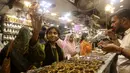 <p>Seorang gadis muda melihat-lihat gelang tradisional saat dia dan yang lainnya mengunjungi pasar untuk berbelanja perayaan Idul Fitri mendatang, di Karachi, Pakistan, Jumat, 29 April 2022. Idul Fitri menandai berakhirnya bulan suci Ramadhan.  (AP Photo/Fareed Khan)</p>