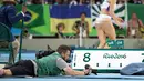 Seorang fotografer terlihat mengatur kameranya sambil tengkurap saat babak final lompat jauh putri pada Olimpiader Rio 2016, Rio de Janeiro, Brasil, (15/8). (REUTERS/Phil Noble)