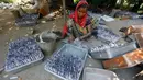 Pekerja India mengisi gulungan kertas dengan bubuk mesiu membuat petasan di sebuah pabrik di pinggiran Ahmadabad, Selasa (15/10/2019).  Menjelang Festival Diwali atau Festival Cahaya, produsen petasan di india dibanjiri pesanan. (AP Photo/Ajit Solanki)
