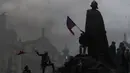 Demonstran memanjat monumen saat berkumpul untuk memprotes tindakan pembatasan COVID-19 di Old Town Square di Praha, Republik Ceko pada 18 Oktober 2020. Ceko  memberlakukan serangkaian tindakan pembatasan baru sebagai tanggapan atas rekor lonjakan infeksi virus corona. (AP Photo/Petr David Josek)