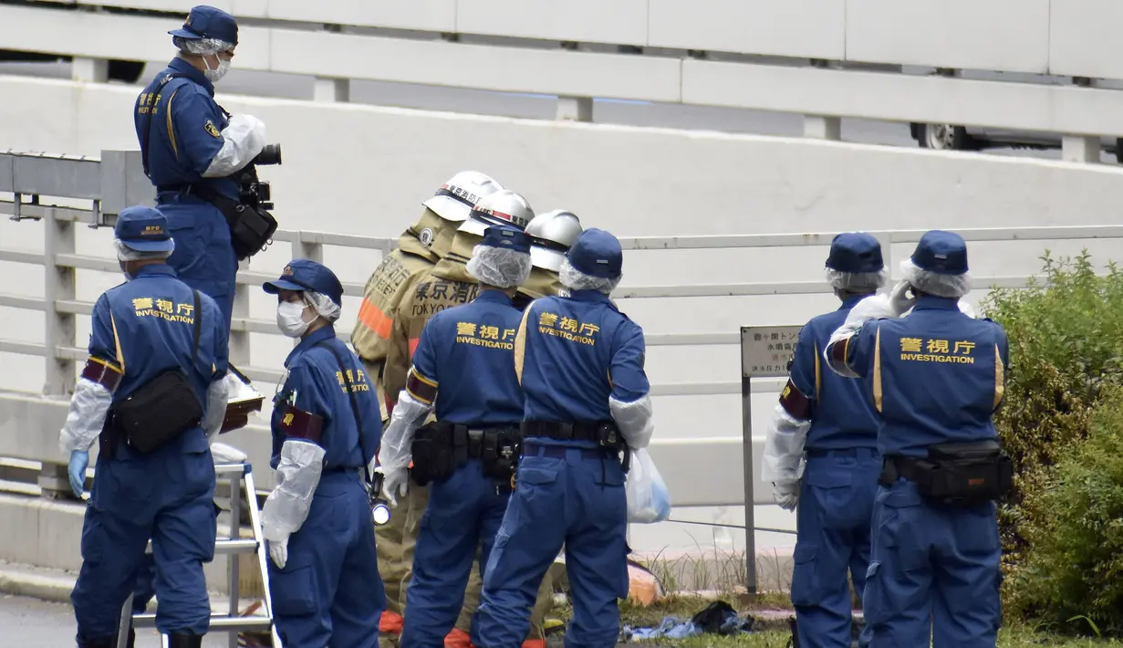 <p>Polisi dan petugas pemadam kebakaran memeriksa tempat kejadian di mana seorang pria dilaporkan membakar dirinya sendiri, di dekat Kantor Perdana Menteri di Tokyo, Rabu, 21 September 2022. Saat ini pria tersebut dalam keadaan tak sadar. Sementara itu, seorang petugas kepolisian yang sempat berupaya memadamkan api juga terluka. (Kyodo News via AP)</p>