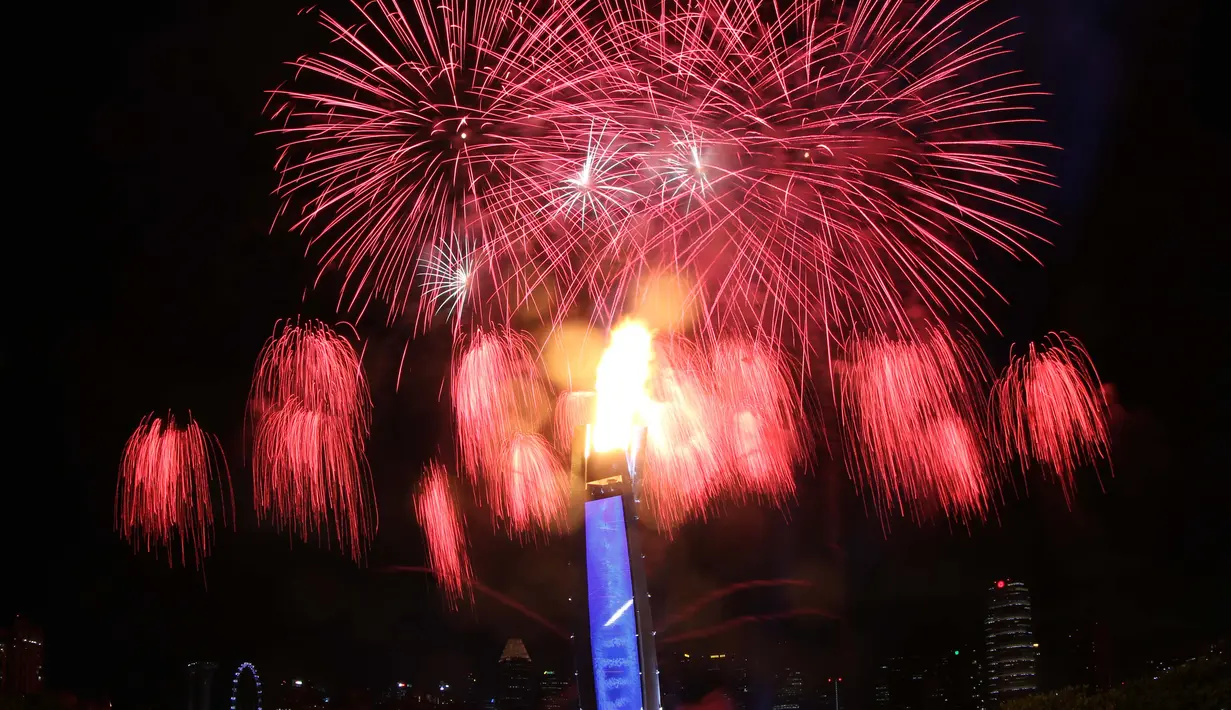 Pesta kembang api yang menjadi latar kaldron api SEA Games menghiasi langit Singapura pada saat Pembukaan SEA Games 2015 di Stadion Nasional Singapura. Jumat (5/6). (Bola.com/Arief Bagus)