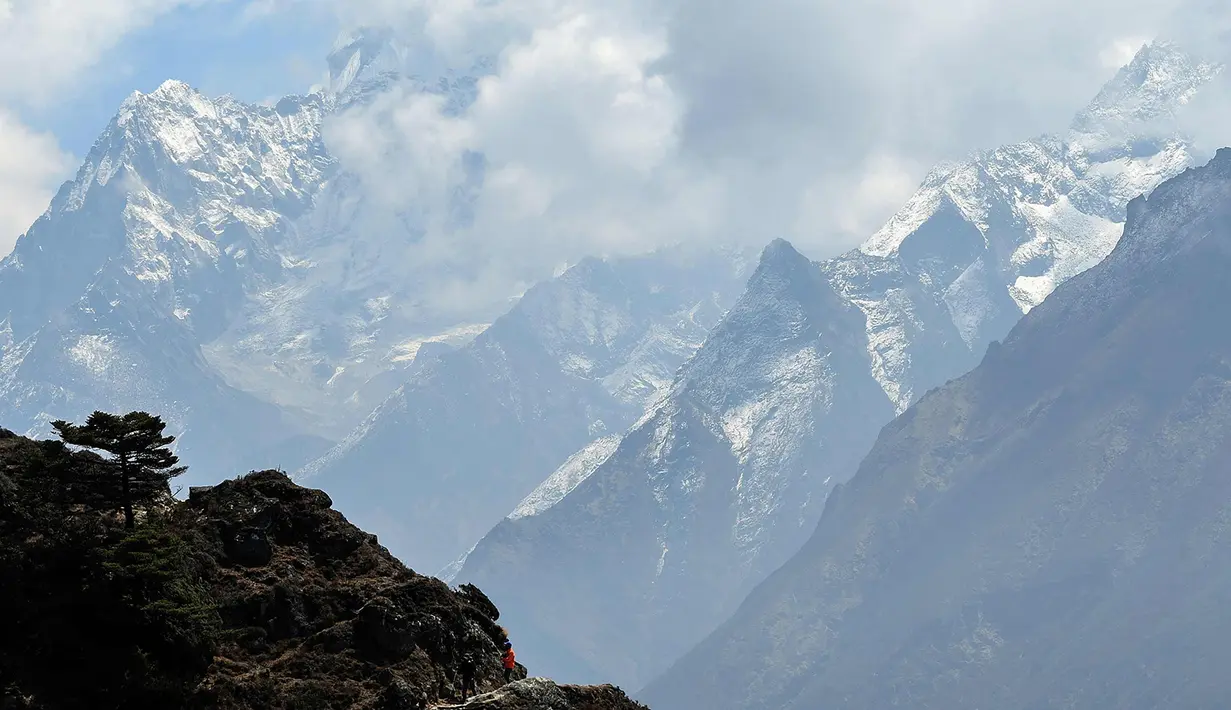Para pendaki berjalan di sepanjang jalan di Syangboche di wilayah Everest, sekitar 140km timur laut Kathmandu (16/4). (AFP Photo/Prakash Mathema)
