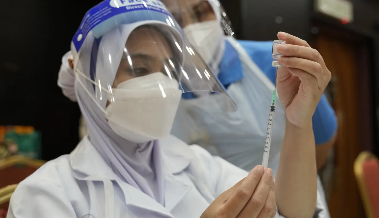 Seorang Perawat menyiapkan dosis vaksin Pfizer terhadap penyakit coronavirus (COVID-19) untuk siswa sekolah menengah di pusat vaksin di Shah Alam, Malaysia, Senin (20/9/2021). (AP Photo/Vincent Thian)