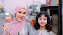 Ayu Ting-ting tampil kembar dengan sang putri kenakan kaftan abu-abu bermotif bunga. Dipadukan dengan kerudung pink dan sling bag hijau yang bikin Ayu Ting-Ting tampil menawan. [@ayutingting92]