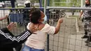 Seorang kerabat narapidana memegang pagar di luar penjara Centro de Privación de Libertad Zona 8 tempat kerusuhan di Guayaquil, Ekuador (23/2/2021). Kerusuhan terjadi akibat dari perkelahian antara geng saingan dan upaya melarikan diri. (AP Photo/Angel Dejesus)