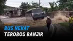 Sopir bus seolah tidak takut mesin bermasalah dan memilih melaju menerobos banjir.
