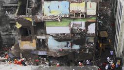 Petugas penyelamat mencari korban di reruntuhan bangunan tempat tinggal tiga lantai yang runtuh di Bhiwandi, India, Senin (21/9/2020). Belum diketahui penyebab kecelakaan, namun kejadian bangunan ambruk sering terjadi di India selama musim hujan yakni antara Juni dan September. (AFP)