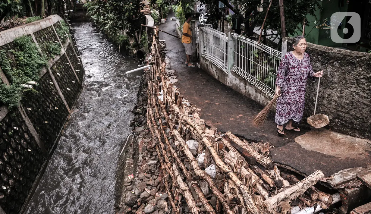 Warga beraktivitas di dekat turap longsor di Batu Ampar, Kramat Jati, Jakarta, Selasa (23/2/2021). Turap kali sepanjang 30 meter di permukiman RT 17 dan 13 RW 02 Kelurahan Batu Ampar longsor pada Sabtu (20/2) akibat derasnya arus air ketika aliran Kali Ciliwung meluap. (merdeka.com/Iqbal S. Nugroho)