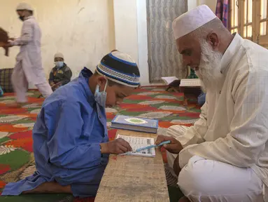 Seorang anak belajar Al-Quran selama bulan suci Ramadan di Jammu Kashmir Al Fallah Yateem Trust, Srinagar, India, Kamis (7/5/2020). Para ulama dan otoritas agama setempat mendesak warga untuk beribadah di rumah untuk mencegah penyebaran virus corona COVID-19. (AP Photo/Dar Yasin)