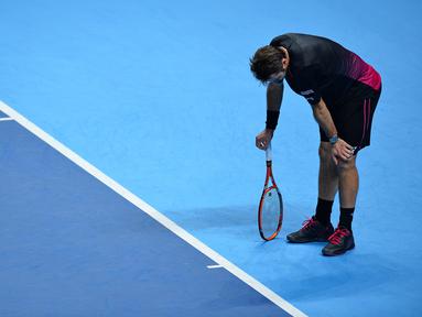 Petenis Swiss, Stanislas Wawrinka, bereaksi saat bertanding melawan petenis Spanyol, David Ferrer, dalam babak penyisihan grup ATP World Tour Finals di London, Inggris, (18/11/2015). (AFP Photo/Glyn Kirk)