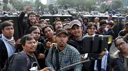 Para pewarta foto itu mengabadikan gaya unik mereka di depan barisan polisi yang memblokade jalan, Jakarta, Kamis (21/8/14).(Liputan6.com/Miftahul Hayat)