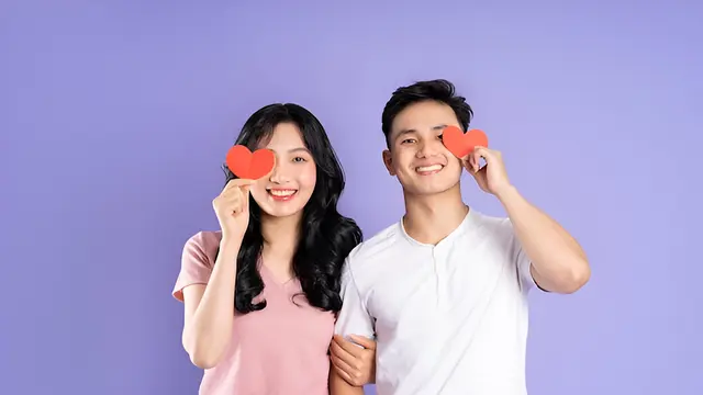 Sepasang kekasih memegang kertas berbentuk hati berwarna merah (Foto Dok: Freepik/1112000)