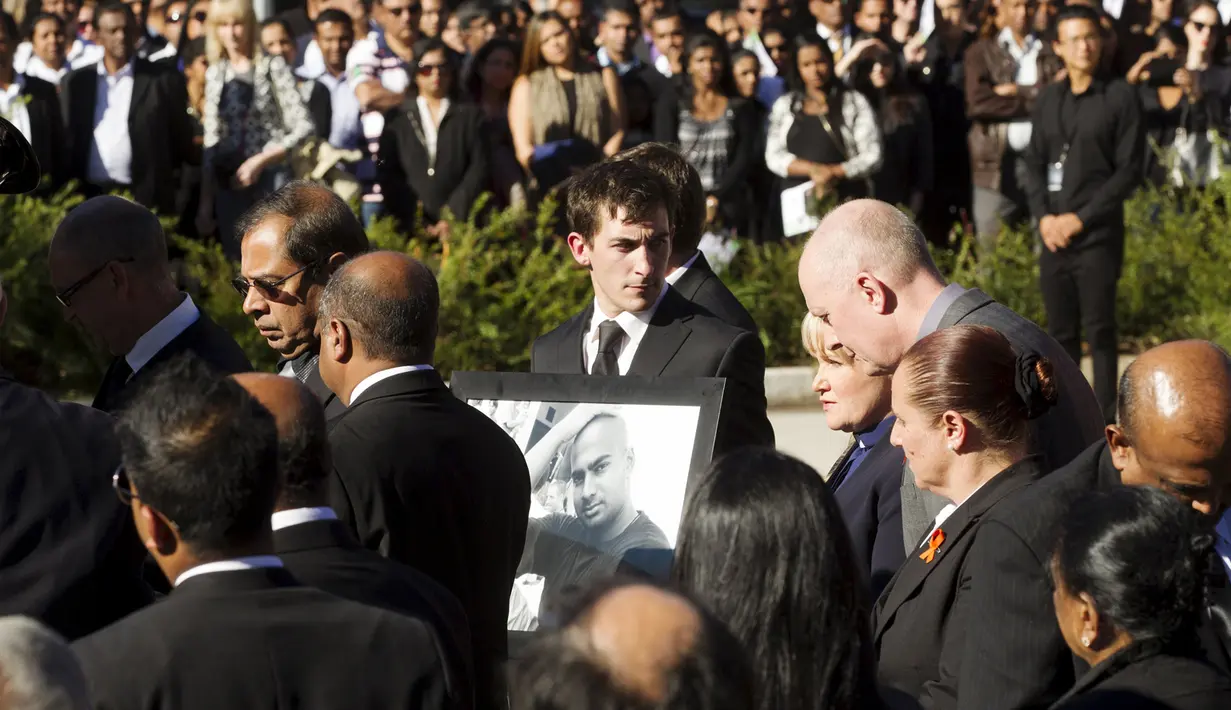 Seorang kerabat membawa bingkai bergambar Myuran Sukumaran asal Australia saat upacara pemakamannya di Gereja, Sydney, Australia, Sabtu (9/5/2015). Myuran Sukumaran dieksekusi mati pemerintah Indonesia pada Rabu 29 April lalu . (REUTERS/Adam Taylor)