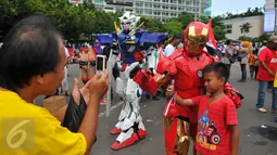 Seorang anak berfoto bersama tokoh robot Iron Man yang meramaikan parade kebudayaan 'Kita Indonesia' di Bundaran HI, Jakarta, Minggu (4/12). Tokoh superhero hingga animasi menjadi incaran peserta parade kebudayaan untuk berfoto (Liputan6.com/Angga Yuniar)
