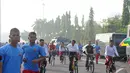 Presiden  Joko Widodo (Jokowi) menyapa warga sambil bersepeda di kawasan Car Free Day, Jakarta, Minggu (23/11/2014) (Liputan6.com/Herman zakharia)