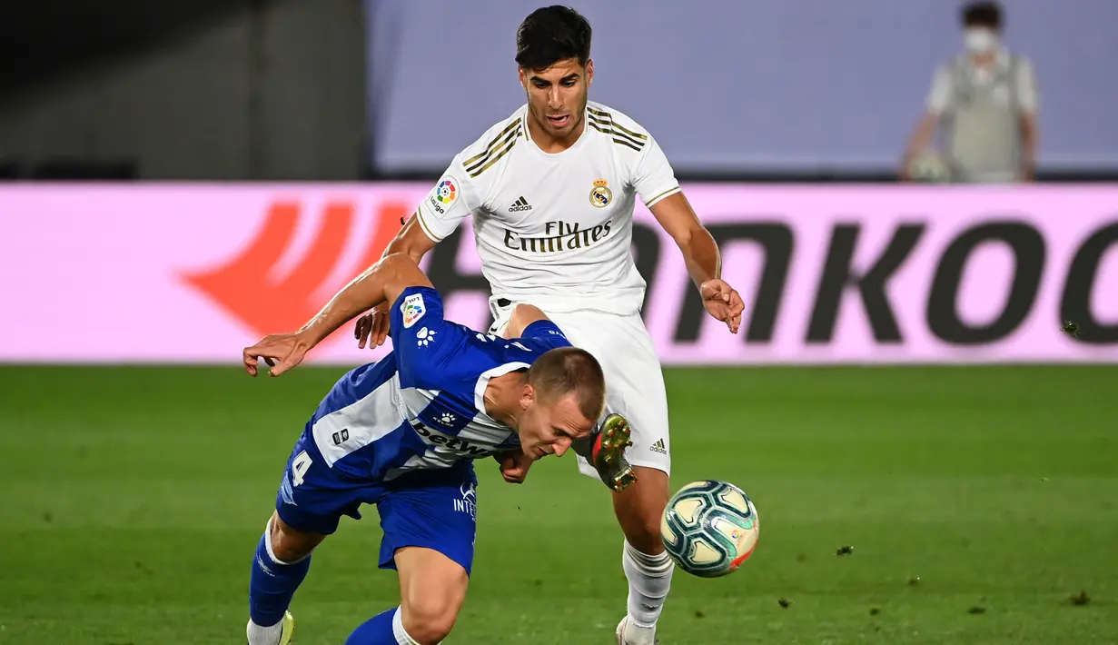 Gelandang Real Madrid, Marco Asensio (kanan) berebut bola dengan bek Alaves, Rodrigo Ely pada lanjutan Liga Spanyol di stadion Alfredo di Stefano, Sabtu (11/7/2020). Real Madrid menang 2-0 lewat gol Karim Benzema dan Marco Asensio. (GABRIEL BOUYS/AFP)
