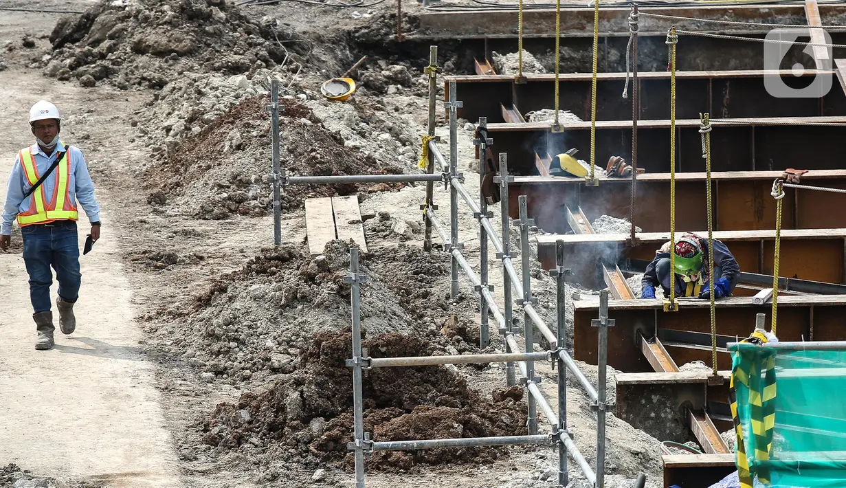 Pekerja berjalan di area proyek Moda Raya Terpadu (MRT) Fase II di Jalan MH Thamrin, Jakarta, Selasa (19/7/2022). Proyek MRT Jakarta Fase 2 CP 201 rute Stasiun Thamrin-Stasiun Monas telah mencapai 40,25 persen. (Liputan6.com/Faizal Fanani)