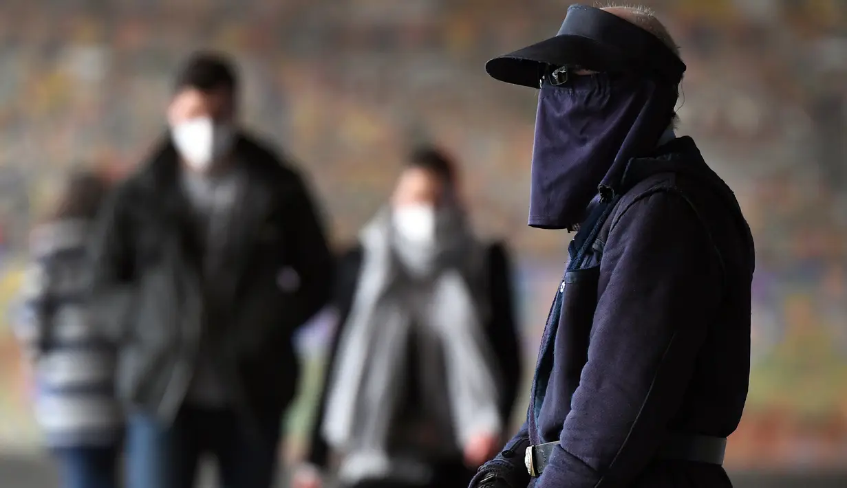 Komuter berjalan melewati Stasiun Flinders Street pada hari pertama wajib masker di tempat umum, di Melbourne, Kamis (23/7/2020). Penduduk kota terpadat kedua di Australia, Melbourne, diwajibkan mengenakan masker ketika meninggalkan rumah untuk mencegah penyebaran COVID-19. (William WEST/AFP)