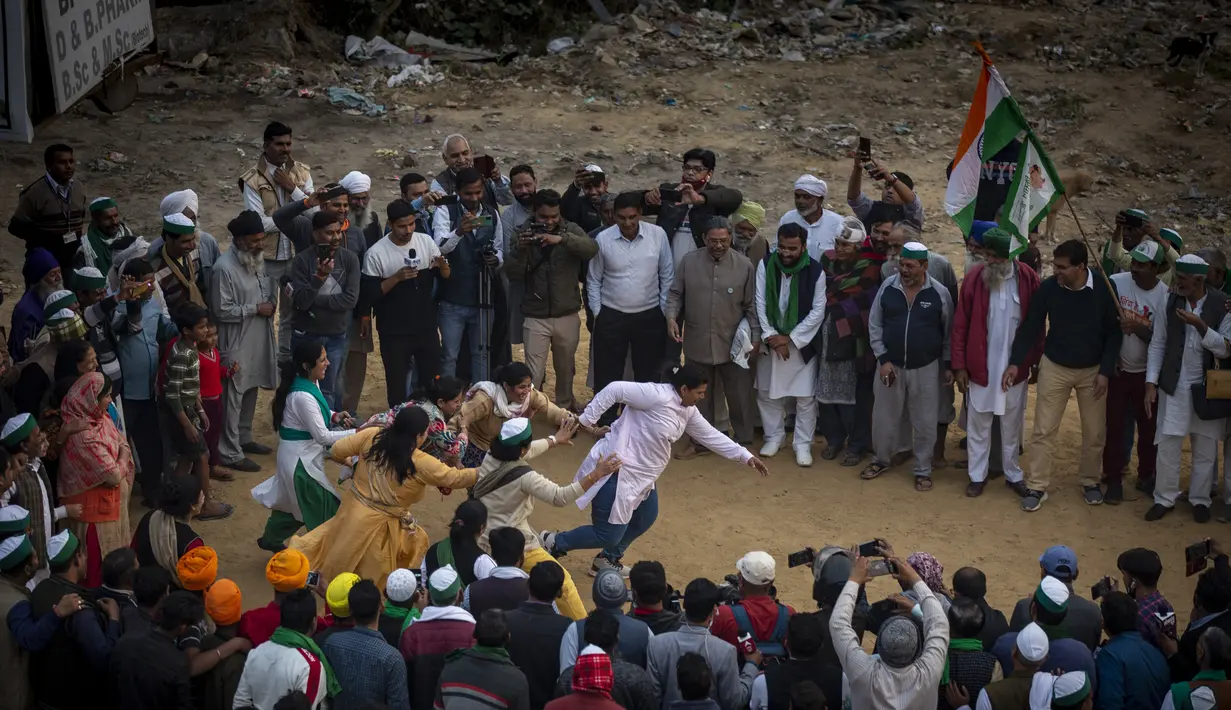 Petani India menyaksikan sekelompok wanita bermain kabbadi di lokasi protes terhadap undang-undang pertanian baru, di Ghazipur, pinggiran New Delhi, India, Kamis (9/12/2021). Petani juga membentuk komite untuk mempertimbangkan tuntutan mereka yang lain. (AP Photo/Altaf Qadri)