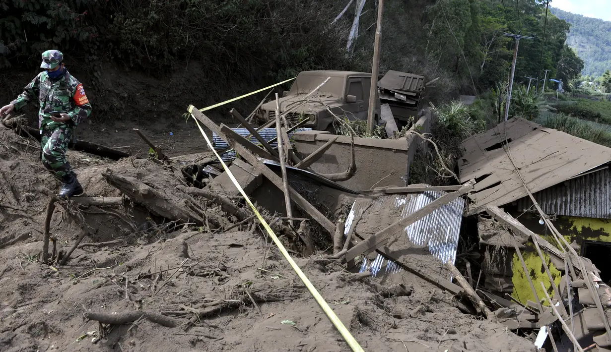 Seorang tentara berjalan melewati rumah-rumah yang rusak akibat tanah longsor yang dipicu gempa bumi di Bangli, di Bali, Sabtu (16/10/2021). Beberapa orang tewas dan lainnya luka-luka saat gempa berkekuatan sedang dan gempa susulan menghantam pulau itu Sabtu dini hari. (AP Photo/Dewa Raka)