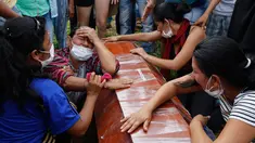 Sejumlah wanita menangis di samping peti mati dalam upacara pemakaman korban banjir dan tanah longsor di Mocoa, Kolombia, (3/4). Musibah ini memakan korban jiwa hingga ratusan orang dan menghancurkan seluruh lingkungan. (AP Photo / Fernando Vergara)