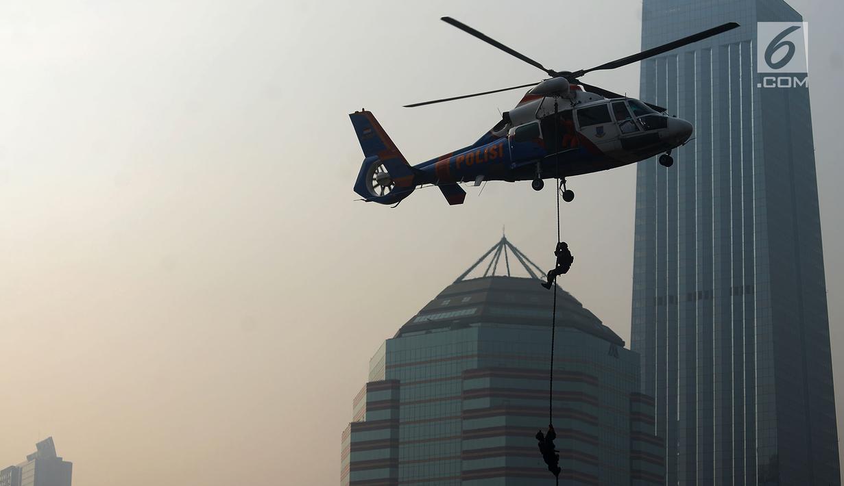 Petugas kepolisian menuruni helikopter menggunakan tali dalam apel pengamanan Asian Games 2018 di Lapangan Ditlantas Polda Metro Jaya, Jakarta, Selasa (31/7). (Merdeka.com/Imam Buhori)