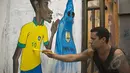 Seorang seniman membuat karikatur Neymar di salah satu tembok di pinggir jalan kota Rio de Janeiro, Jumat (9/5/2014) (AFP PHOTO / Vanderlei Almeida).