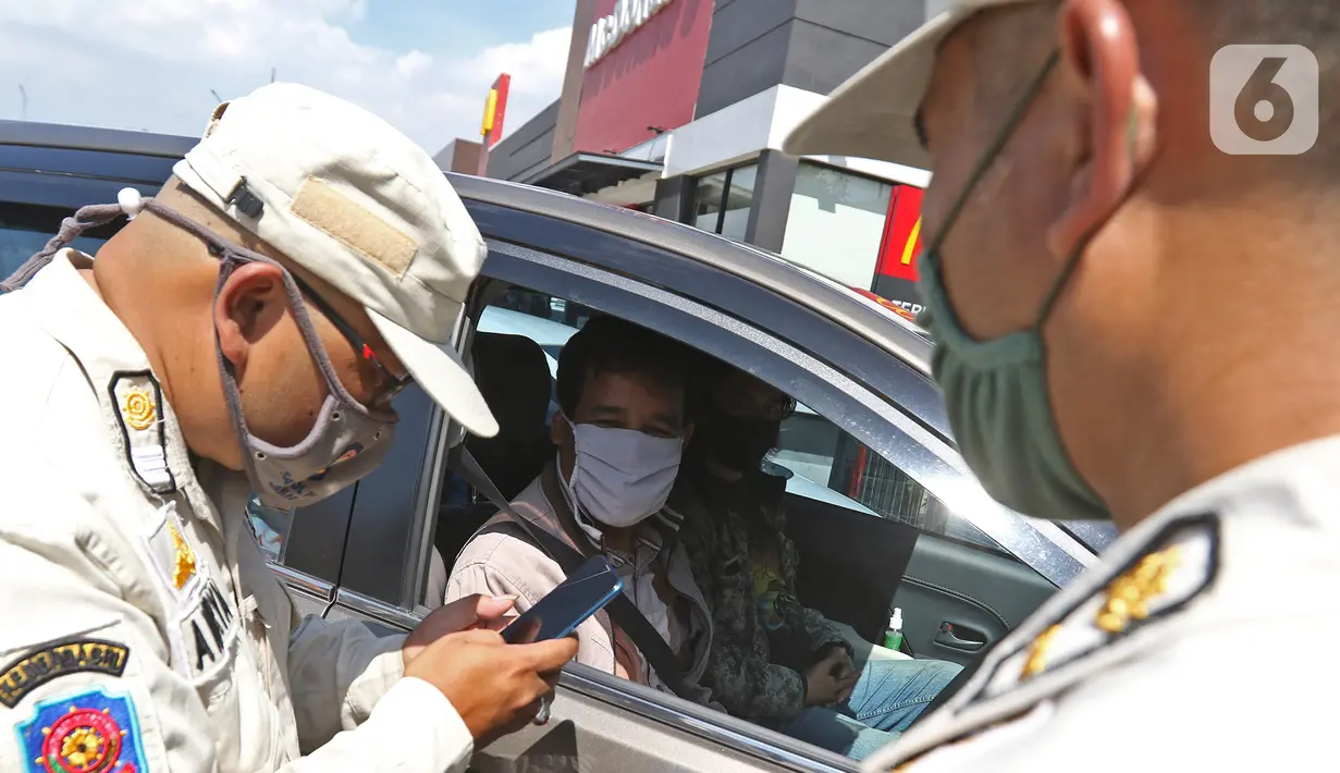 Petugas melihat hasil rapid test antigen pengemudi di Rest Area KM 57, Tol Jakarta-Cikampek, Karawang, Jawa Barat, Kamis (24/12/2020). Warga yang tidak memiliki surat keterangan non reaktif Covid-19 diminta untuk melakukan rapid test antigen ditempat yang disediakan. (Liputan6.com/Herman Zakharia)