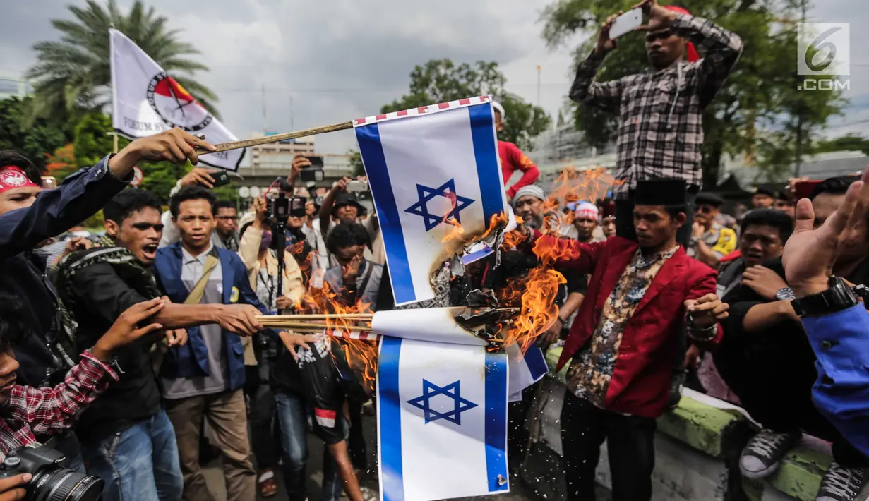 Massa berunjuk rasa dengan membakar bendera Israel dalam Aksi Bela Palestina di Kedubes Amerika Serikat, Jakarta, Jumat (15/12). Aksi itu sebagai simbol penolakan terhadap AS yang mengakui Yerusalem sebagai Ibu Kota Israel. (Liputan6.com/Faizal Fanani)