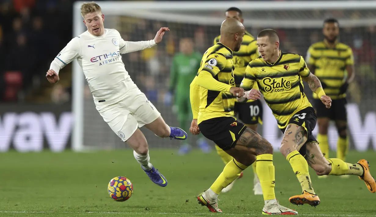 Gelandang Manchester City, Kevin De Bruyne terjatuh setelah ditekal pemain Watford, William Troost-Ekong pada pertandingan lanjutan Liga Inggris di Stadion Vicarage Road di Watford, Inggris (4/12/2021). City menang atas Watford 3-1. (AP Photo/Ian Walton)