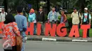 Warga melintas di depan aksi #masihingat yang dilakukan sejumlah keluarga korban kekerasan di Taman Gunung Agung Jakarta, Rabu (29/6). Aksi ini mengingatkan masih banyak kasus pelanggaran HAM yang belum tuntas. (Liputan6.com/Helmi Fithriansyah)