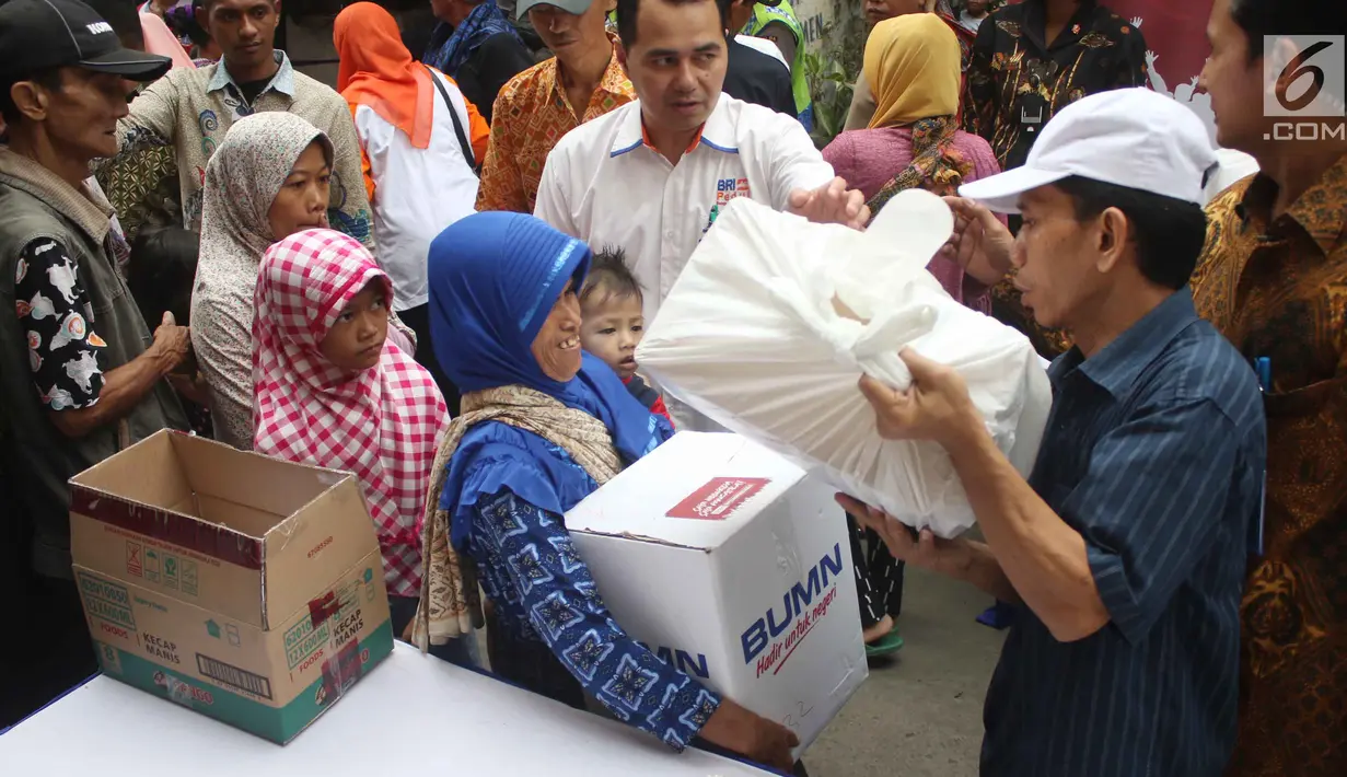 Warga menerima paket sembako Ramadan dari BUMN di Kecamatan Penjaringan, Jakarta, Selasa (13/6). Satu paket sembako yang dibagikan di Jalan Rawa Bebek ini senilai Rp 350 ribu, yang terdiri dari bahan kebutuhan pokok. (Liputan6.com/Angga Yuniar)